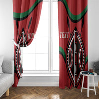 Red window curtain panels framing a doorway with black and white geometric print and green curves