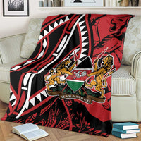 Red, black and white blanket draped over sofa with lions crest and geometric pattern