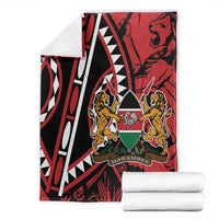 Red and black geometric blanket with lions crest, stacked with white towels