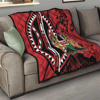 Red quilt blanket on sofa with black-and-white design and Harambe emblem