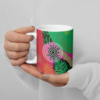 Ceramic mug with pink and green floral leaf pattern, held by hands, white interior