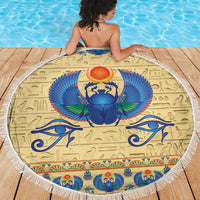 Beige round beach blanket with fringe border featuring blue winged scarab and eyes