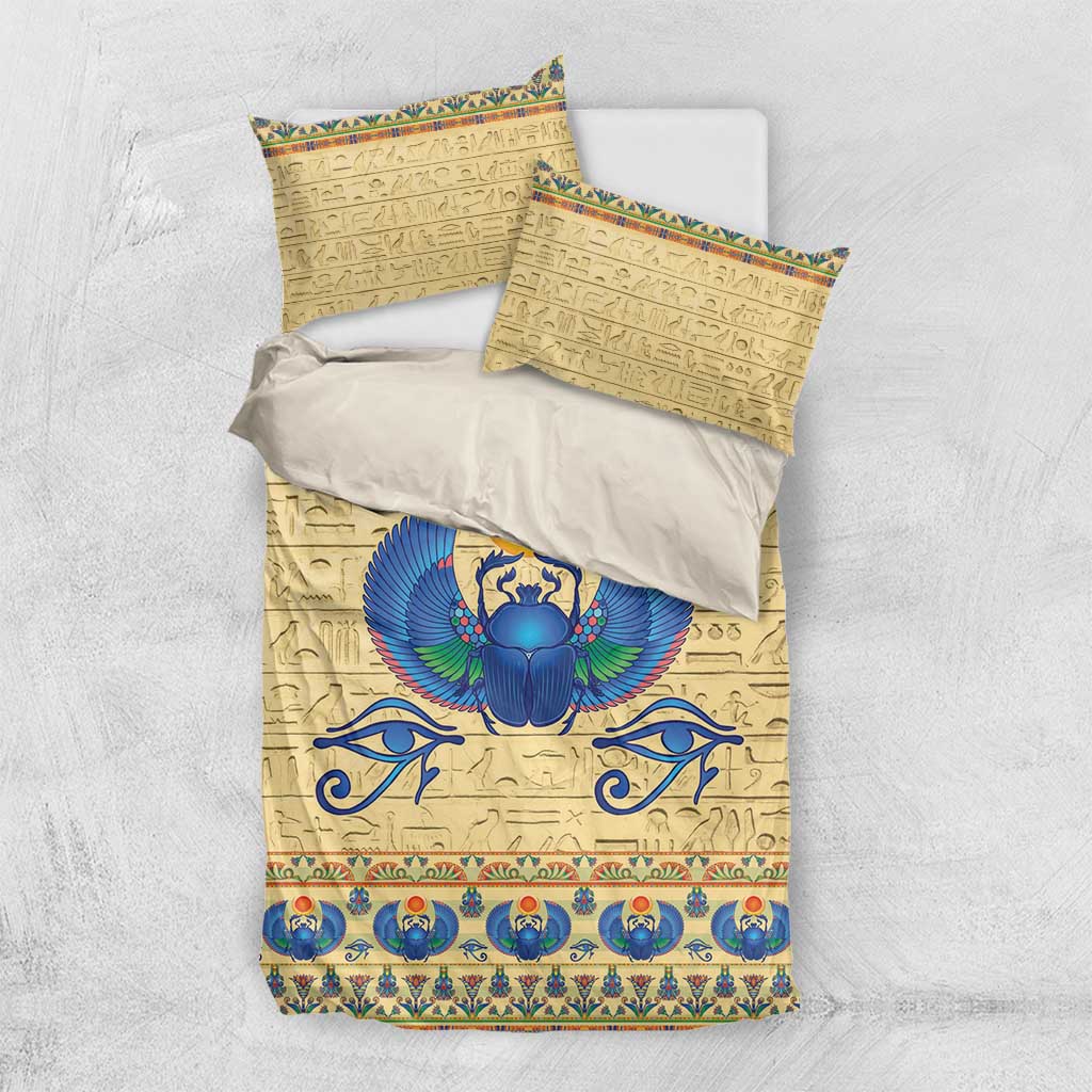 Beige bedding set with pillowcases and duvet, blue scarab beetle emblem and hieroglyph motifs