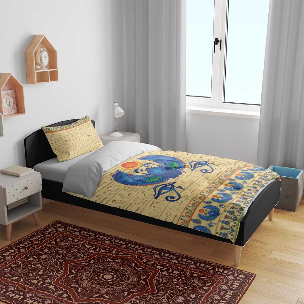 Beige duvet cover and pillowcases with blue scarab beetle emblem and blue decorative border