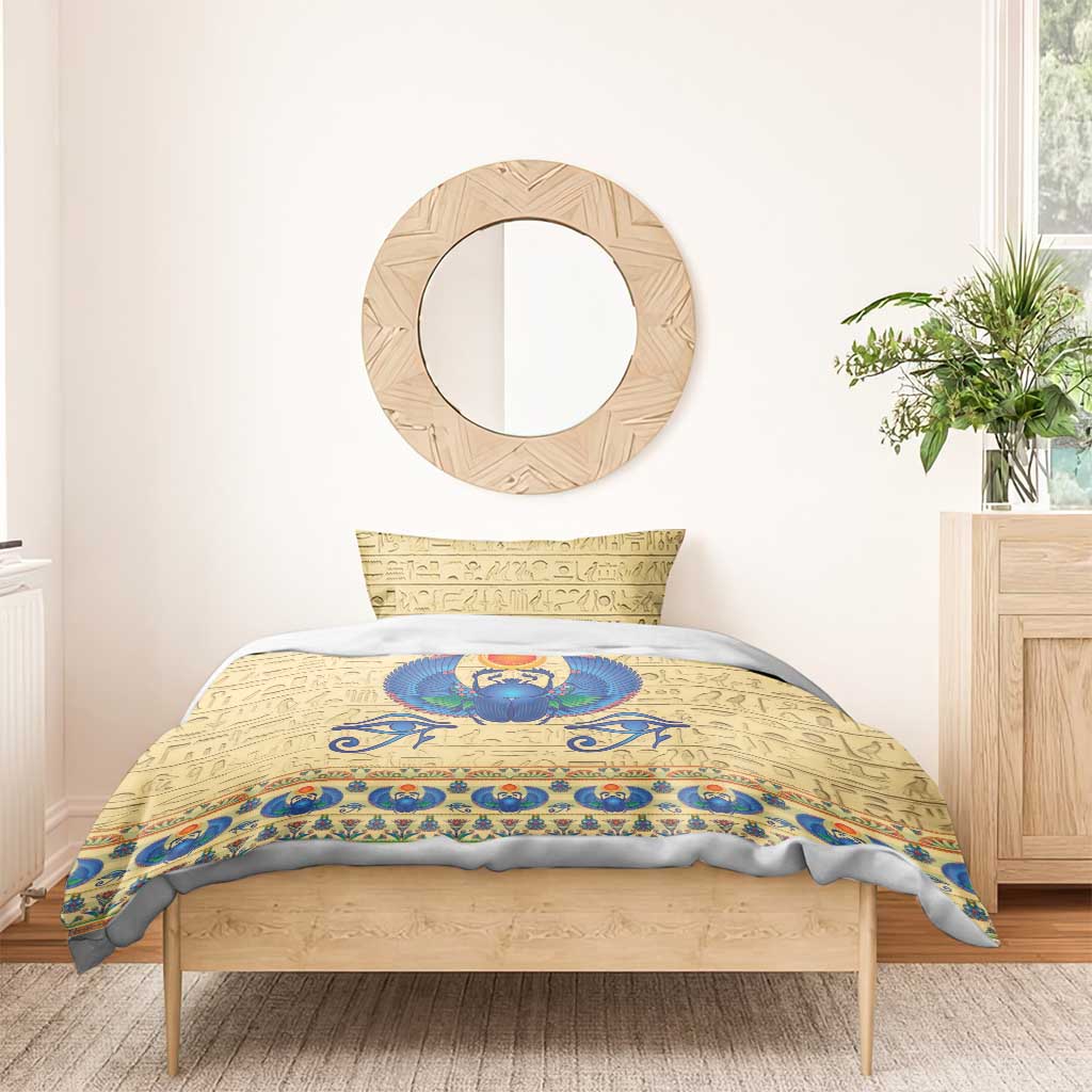 Beige bedding set with blue winged scarab beetle, red sun disk, and hieroglyph background