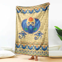 Beige scarab beetle blanket draped vertically with blue winged scarab center and trim