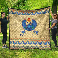 Beige scarab beetle quilt with blue Egyptian pattern border and central winged figure