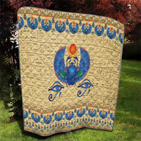 Beige quilt with blue winged scarab beetle artwork and ornate top and bottom borders