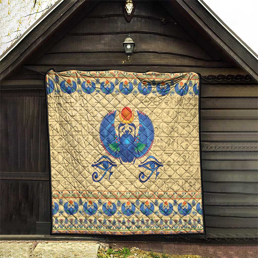 Beige quilt featuring blue winged scarab beetle design with multicolor border bands