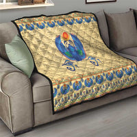 Beige quilt throw on sofa with blue winged scarab beetle motif and decorative border