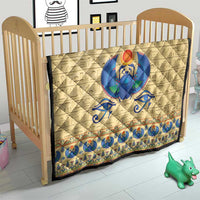 Beige crib quilt with blue winged scarab beetle center and patterned border trim