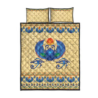 Beige quilt bed set with blue scarab beetle design, ornate border, and two pillows
