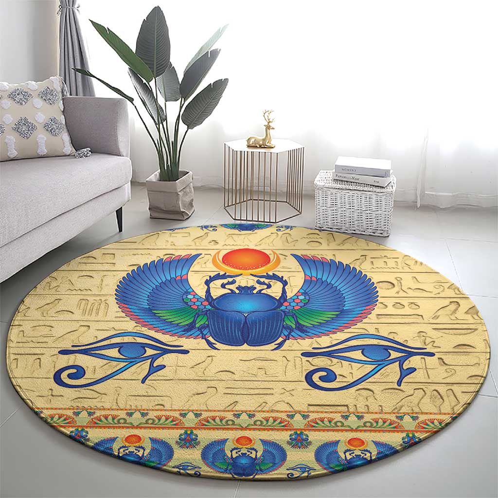 Beige round carpet rug with a large blue scarab beetle medallion and wings
