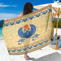 Beige Egyptian scarab beetle sarong with blue hieroglyph and border print, flat laid
