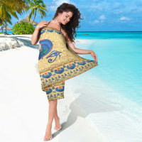 Beige Egyptian scarab sarong with blue beetle graphic and hieroglyph pattern, draped