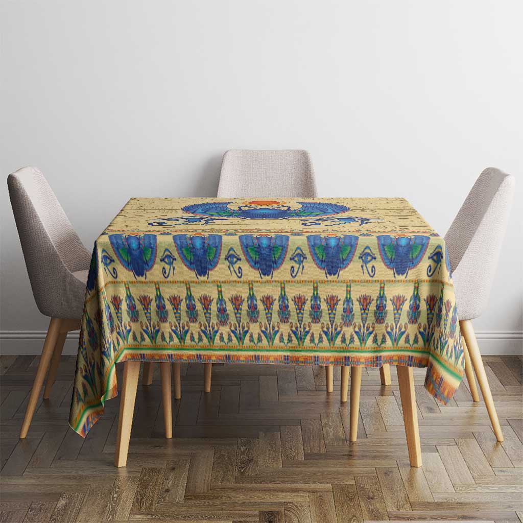 Beige tablecloth with blue scarab beetle and ornate Egyptian pattern on dining table