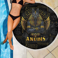 Black round beach blanket with Anubis graphic, white fringe trim, draped beside pool
