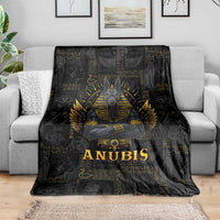 Black Anubis throw blanket draped over gray sofa, gold hieroglyph pattern
