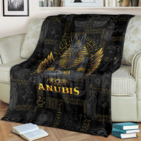 Black Anubis throw blanket on cream sofa, gold winged emblem and text