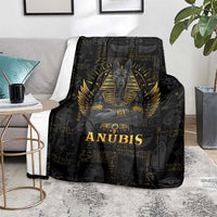 Black Anubis throw blanket on gray floor with gold winged portrait