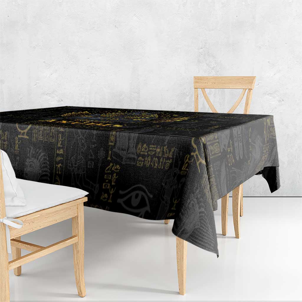 Black tablecloth draped over a table edge, featuring gold hieroglyph designs