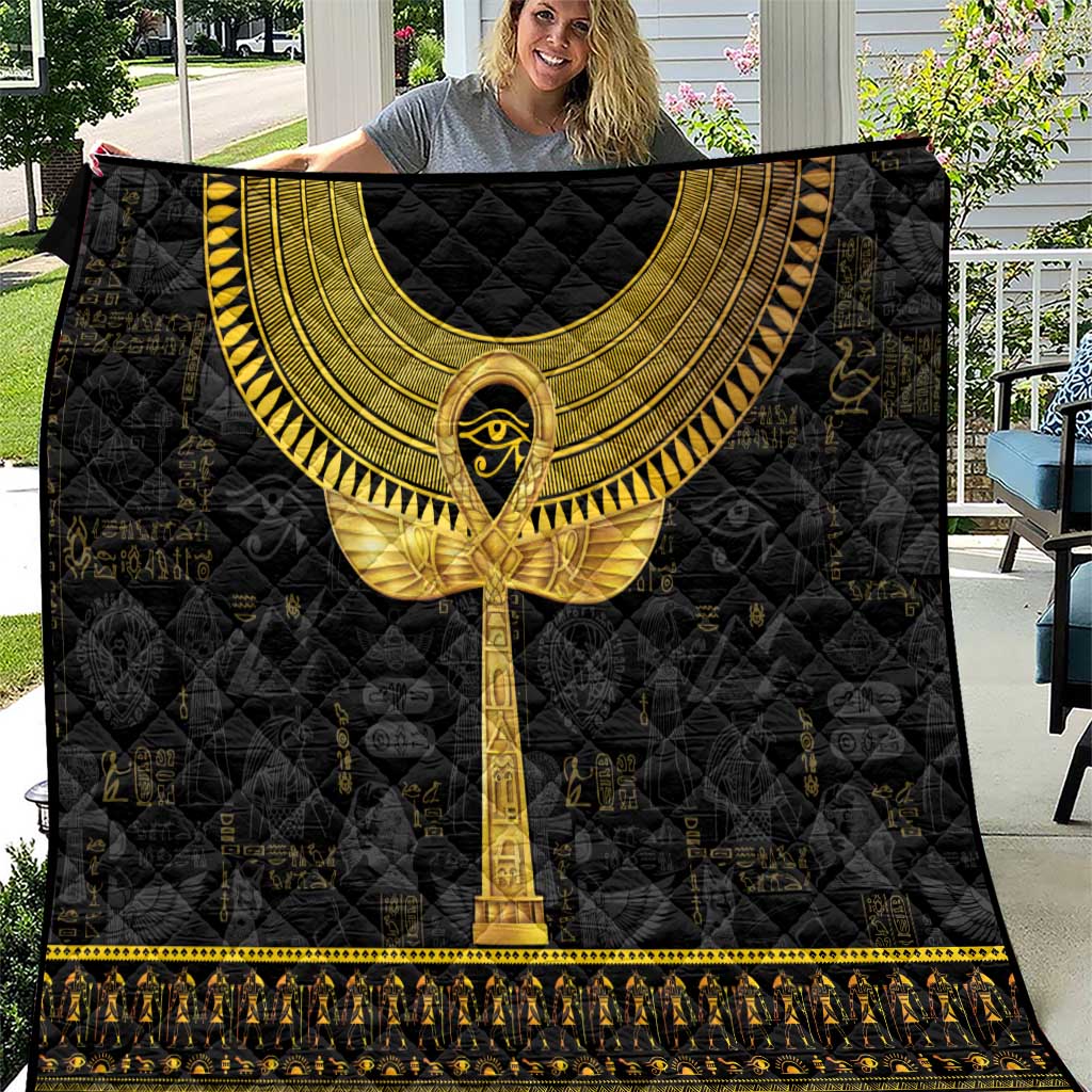 Black Egyptian hieroglyphs quilt with gold ankh and ornate border, spread flat