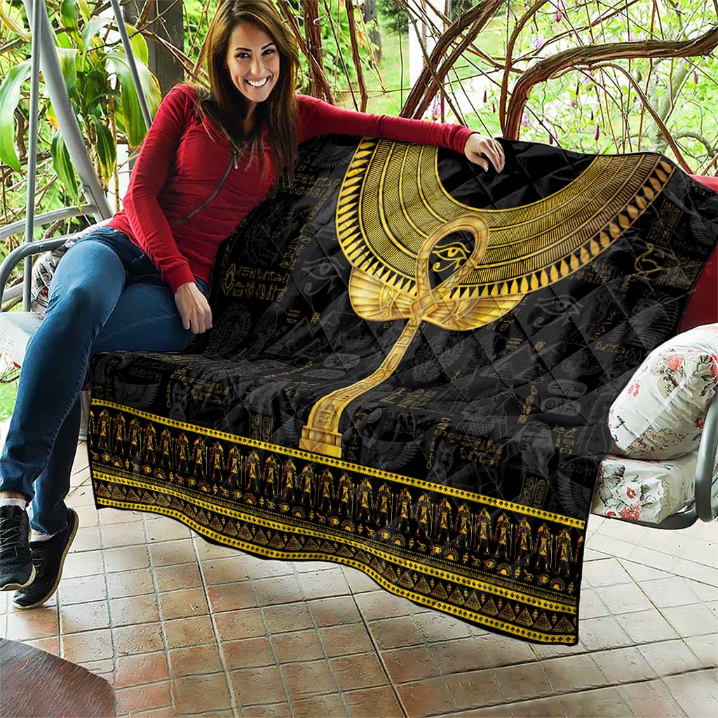 Black Egyptian hieroglyphs quilt with gold ankh symbol and ornate gold edging, draped
