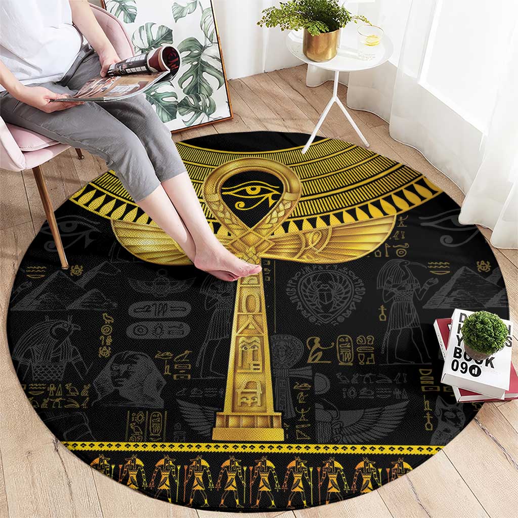 Black round carpet with gold Egyptian ankh column design and hieroglyphs, patterned edge.