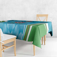 Blue tablecloth with green panel over bench, geometric stripe and emblem print