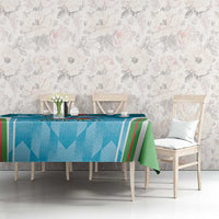 Blue tablecloth with green accent stripe, printed emblem motif on dining table