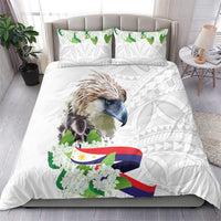 White duvet and two pillows featuring bird, green floral accents, flag ribbon, and geometric design
