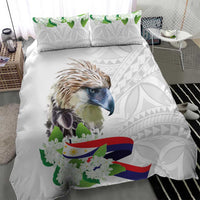 White comforter with bird portrait center, green blossoms, flag ribbon, and light gray pattern