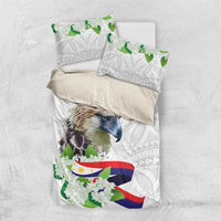 White duvet cover with bird print, green blossoms, flag ribbon, plus matching pillowcases