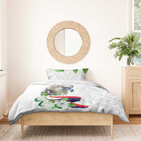 White duvet with bird and green floral accents, flag ribbon center, on light wooden bed