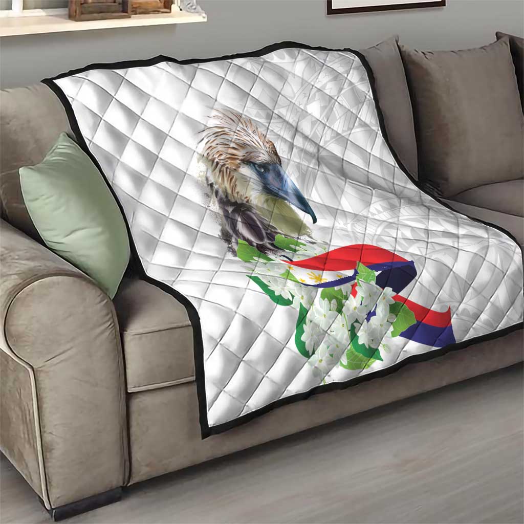 White diamond-quilted throw blanket on a sofa, featuring an eagle, flag, and sampaguita flowers.