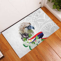 White rectangular doormat with eagle and floral design on gray geometric background