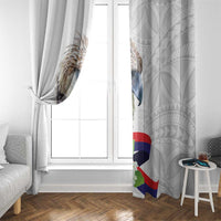 White curtain beside a window with tied fabric panels and eagle-and-flag print