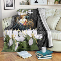 Black throw blanket draped on sofa with eagle emblem, white flowers, and dark geometric border