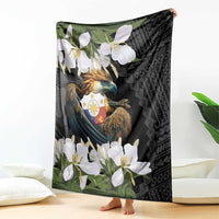 Black blanket hanging display with eagle artwork, white flowers, and green plant accents
