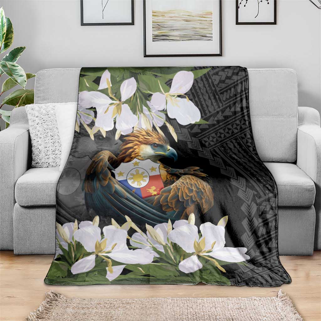 Black eagle-and-flowers blanket spread on sofa with white blossoms and green foliage