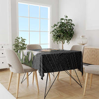 Black tablecloth with eagle and coat of arms over geometric pattern, with white flowers