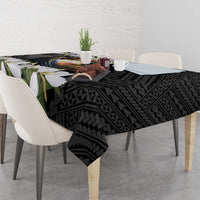 Black tablecloth corner view with eagle emblem, geometric motifs, and green leaf accents