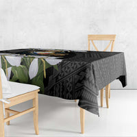 Black tablecloth draped on table with eagle emblem and geometric pattern beneath floral border