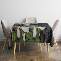 Black tablecloth on small dining table with eagle emblem, white flowers, and green foliage