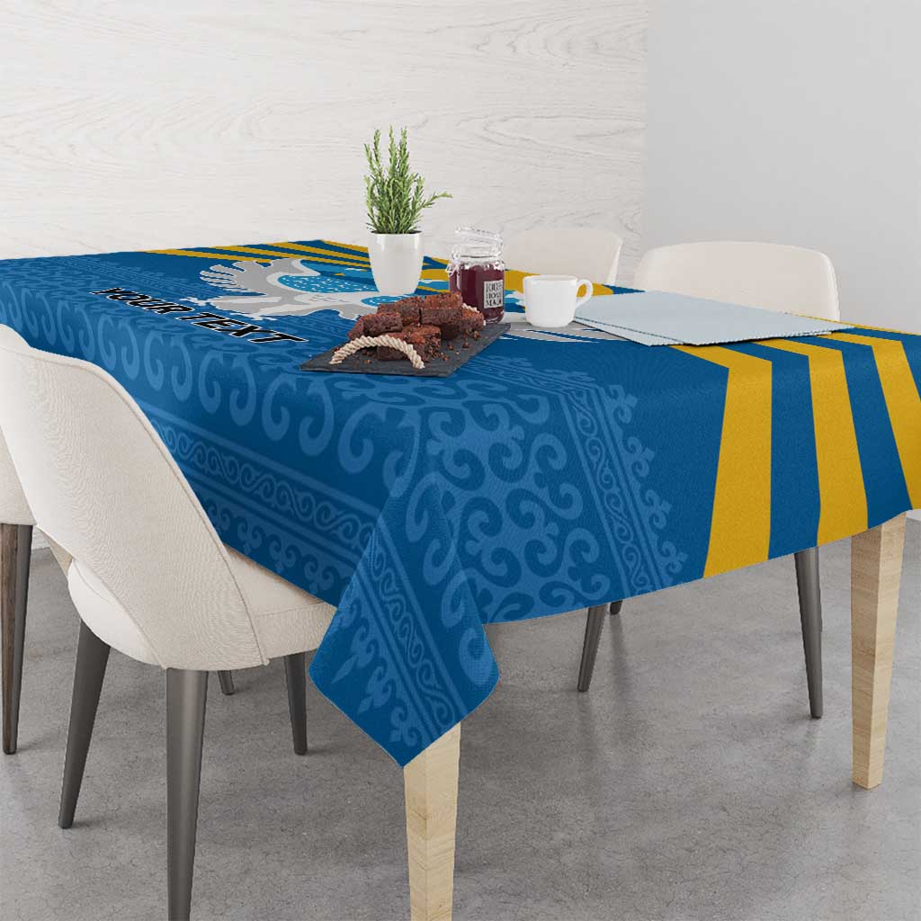 Blue personalized tablecloth with falcon wing and mountain design, draped over table.
