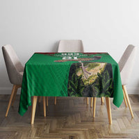 Green tablecloth with landscape graphic on tabletop, set on four chairs