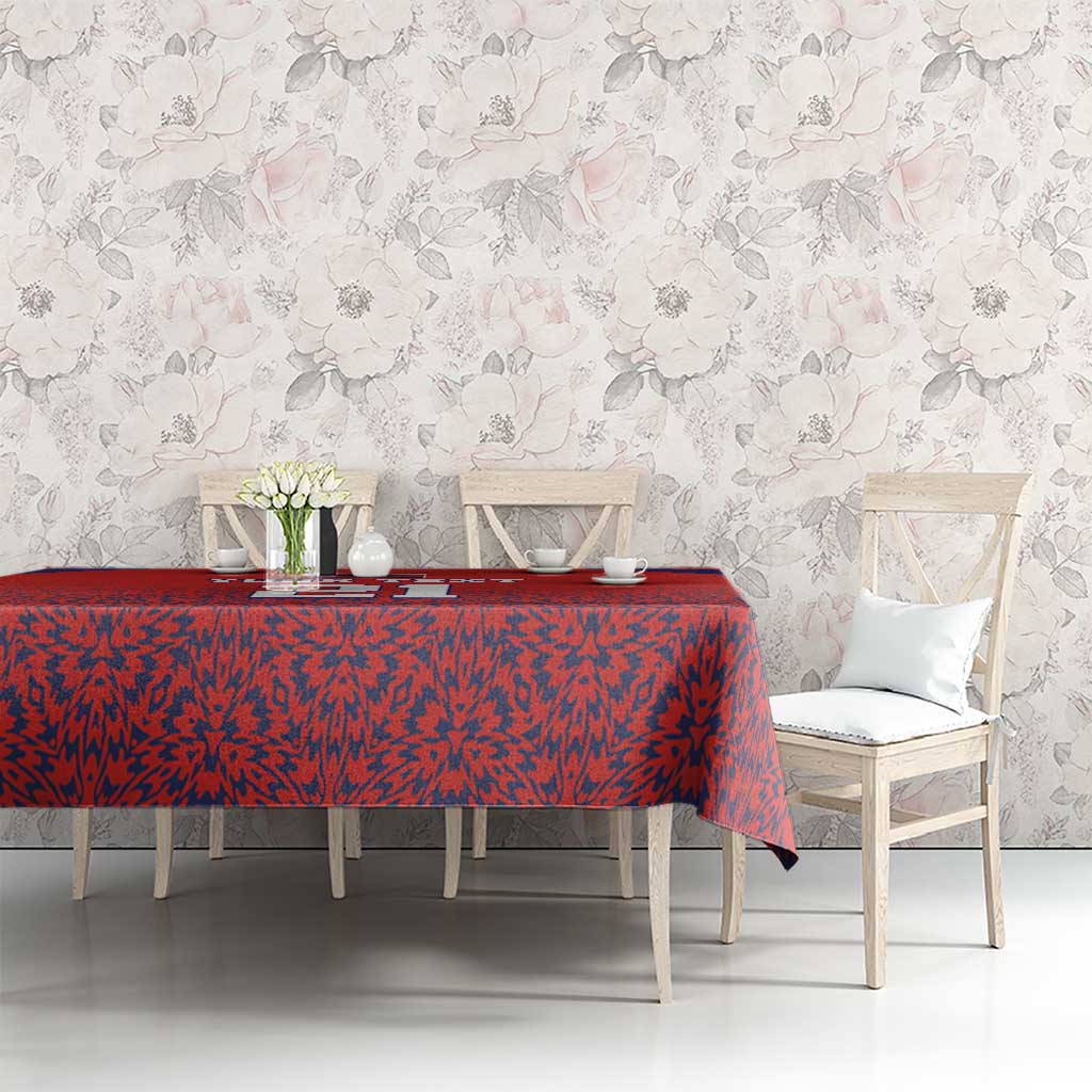 Red custom tablecloth with blue edge stripe and abstract black-red pattern on long table.
