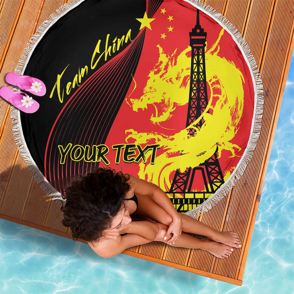 Round fringed beach blanket showing dragon, Eiffel Tower, and “YOUR TEXT” lettering