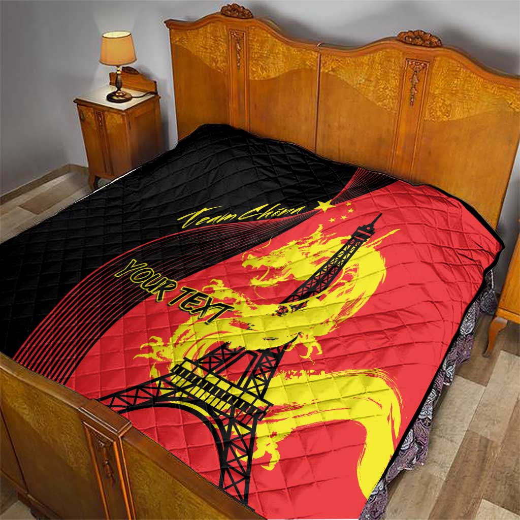 Red and black quilted blanket with Eiffel Tower and dragon print on bed