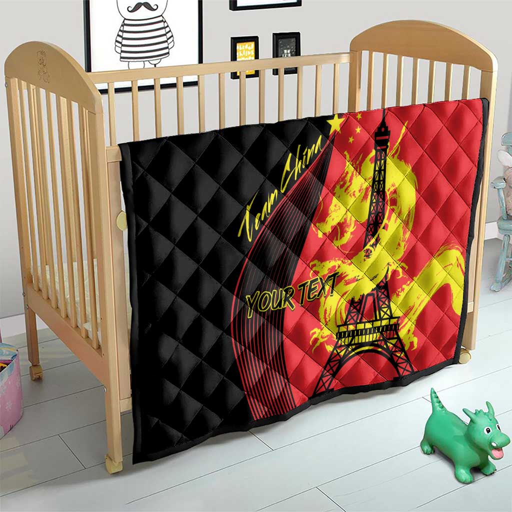 Red and black quilted baby blanket with Eiffel Tower and dragon print on crib